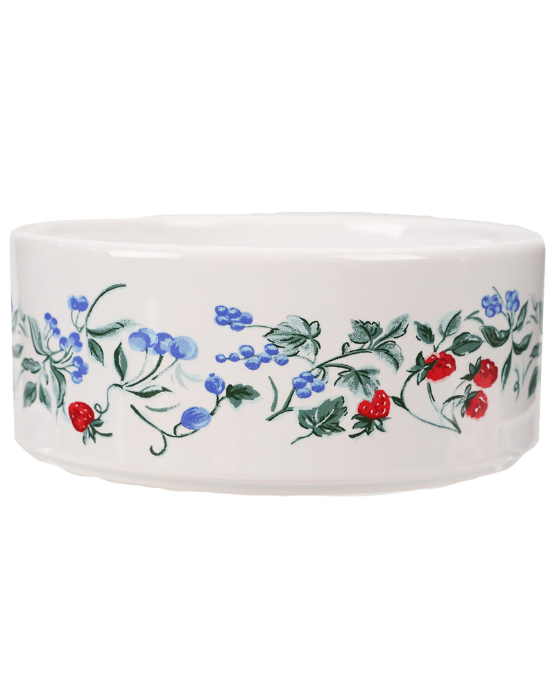 A white ceramic bowl decorated with a delicate floral border featuring blue flowers, green leaves, and red berries, shown against a plain white background.