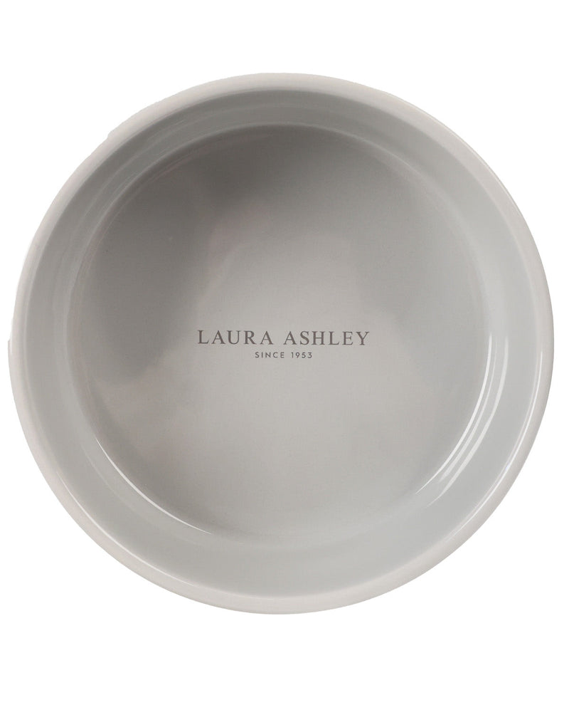 A top-down view of a light gray ceramic bowl with 'LAURA ASHLEY SINCE 1933' printed in the center, on a solid white background.