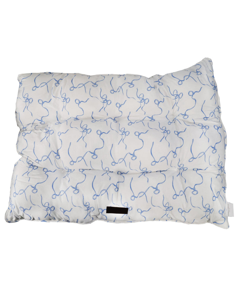 A white quilted cushion or pillow with a light blue scribble pattern, shown against a plain white background.