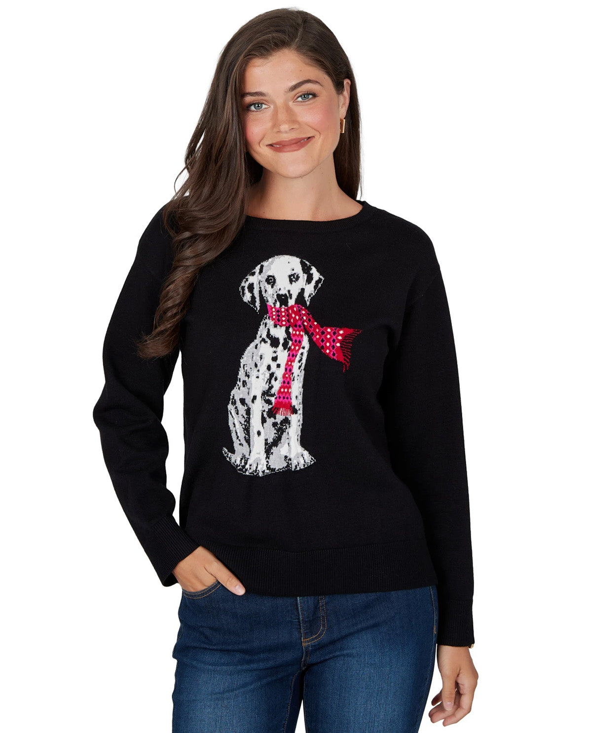 A woman wearing a black crewneck sweater with a sequined Dalmatian dog graphic wearing a red polka-dot bow tie, paired with blue jeans against a white background.