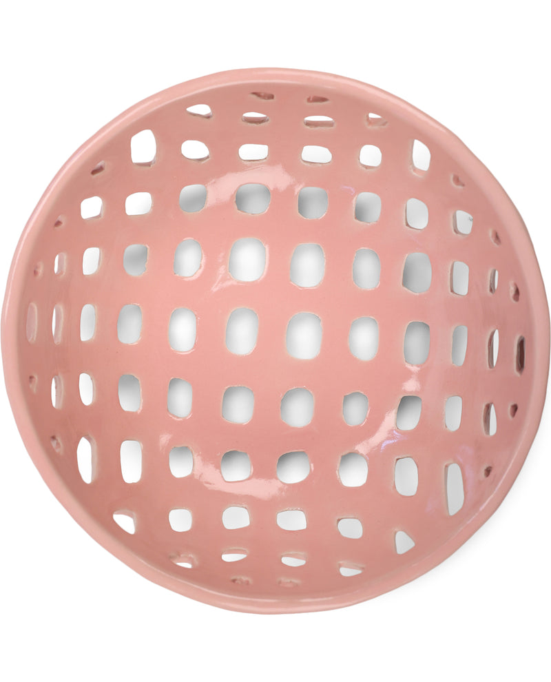 A glossy, round pink ceramic bowl with a perforated grid pattern, shown from a top-down view on a white background.