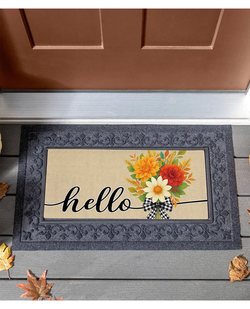 A rectangular doormat with a dark gray ornate border and a beige center panel that reads "hello" in black script. The right side of the mat features a colorful floral arrangement with yellow, orange, red, and white flowers, green leaves, and a black-and-white gingham bow.