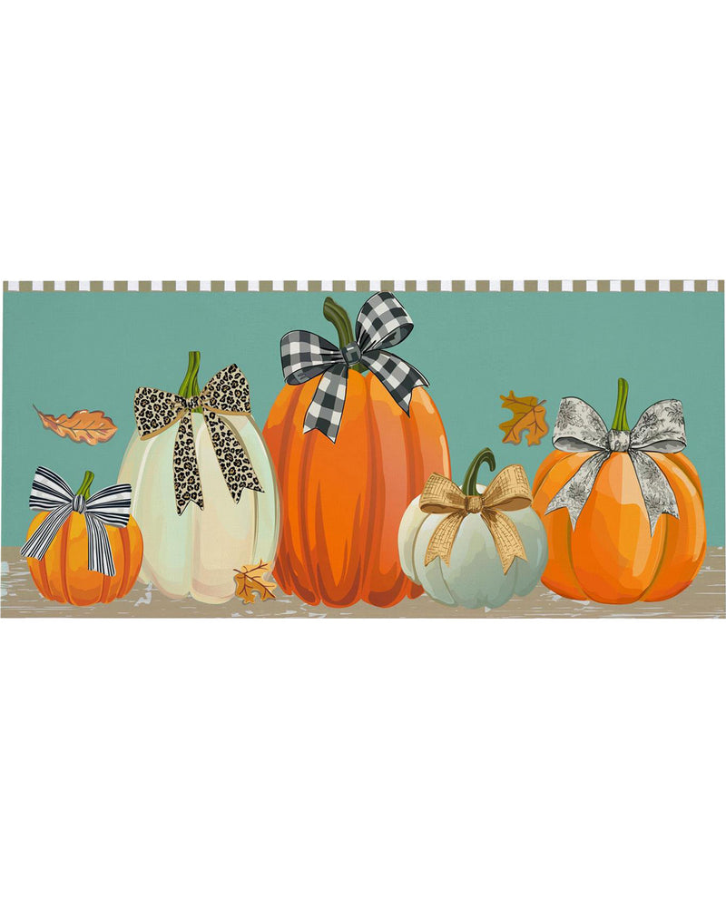 A horizontal decorative banner or tape featuring illustrated pumpkins in orange, cream, and pale blue with black-and-white, leopard-print, tan, and silver bows, set against a teal background with a striped border at the top.