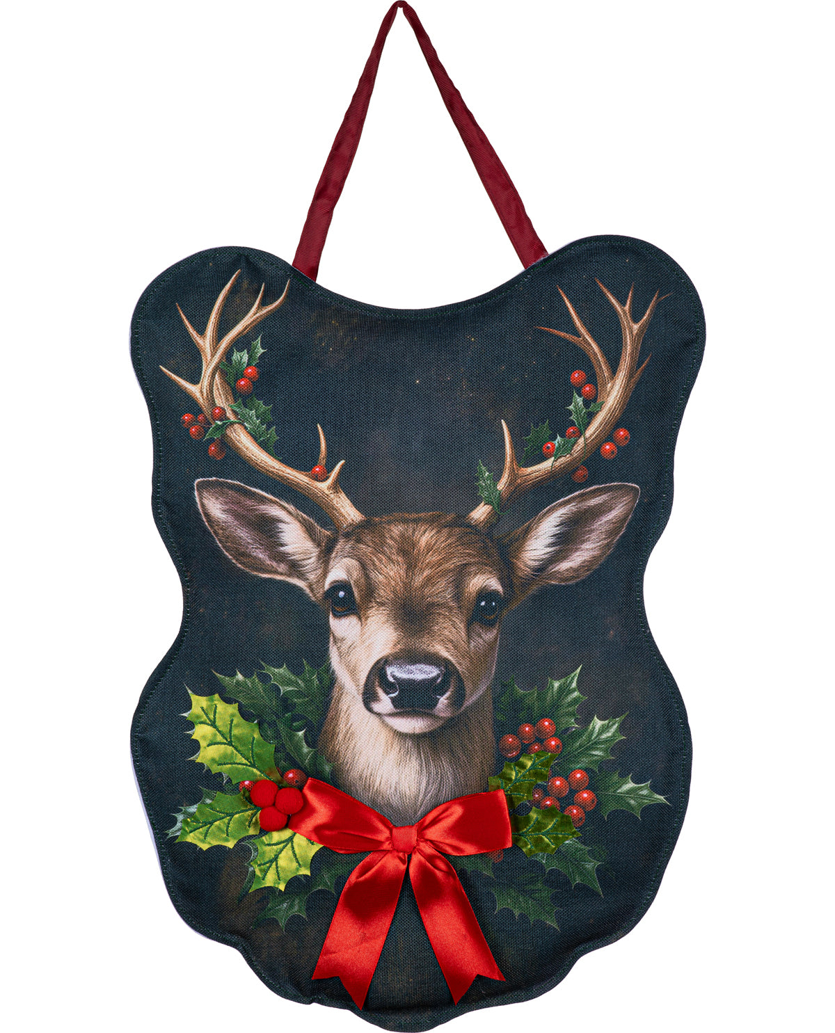 A decorative hanging plaque shaped like a deer head, featuring a painted deer face with antlers, green holly leaves, red berries, and a large red bow on a dark background, with a red hanging loop at the top.