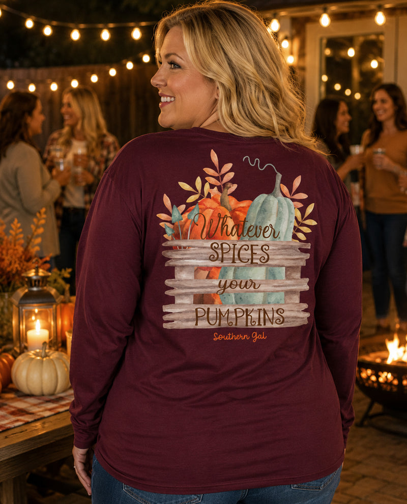 Woman wearing a maroon long-sleeve shirt with a fall-themed design, standing in a festive outdoor setting.