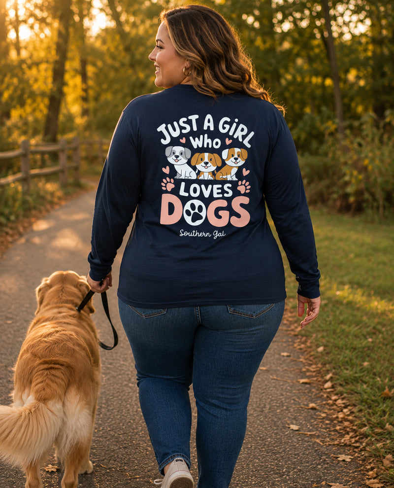 Woman walking a dog on a path with a shirt that says 'Just a girl who loves dogs' in a park setting.