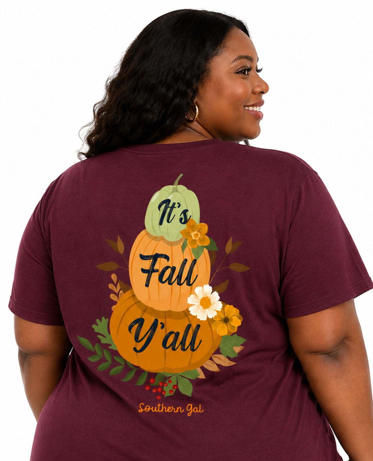 Woman wearing a maroon t-shirt with a fall-themed design on the back.