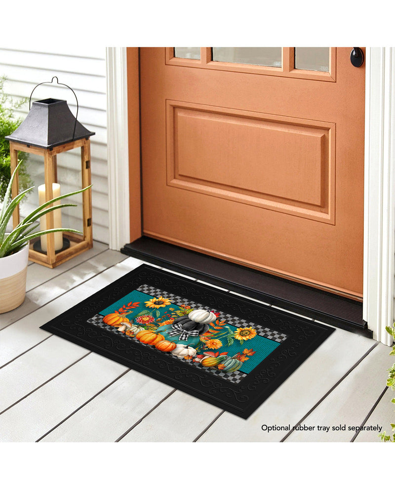 Decorative doormat with autumn design in front of a brown door.