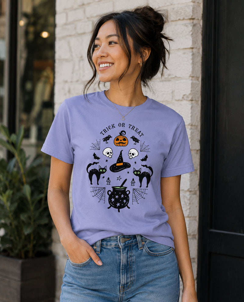 Woman wearing a purple Halloween-themed t-shirt with black graphics against a brick wall.