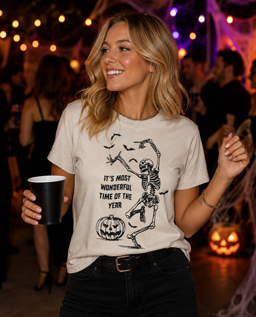 Woman wearing a Halloween-themed t-shirt with a skeleton design at a party.