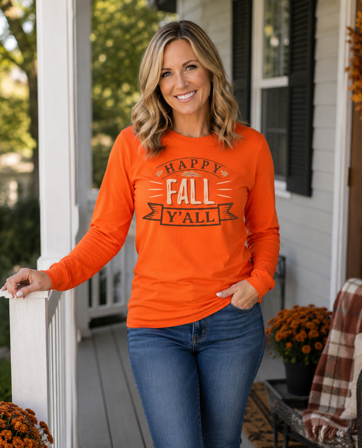 Woman wearing an orange 'Happy Fall Y'all' shirt on a porch.