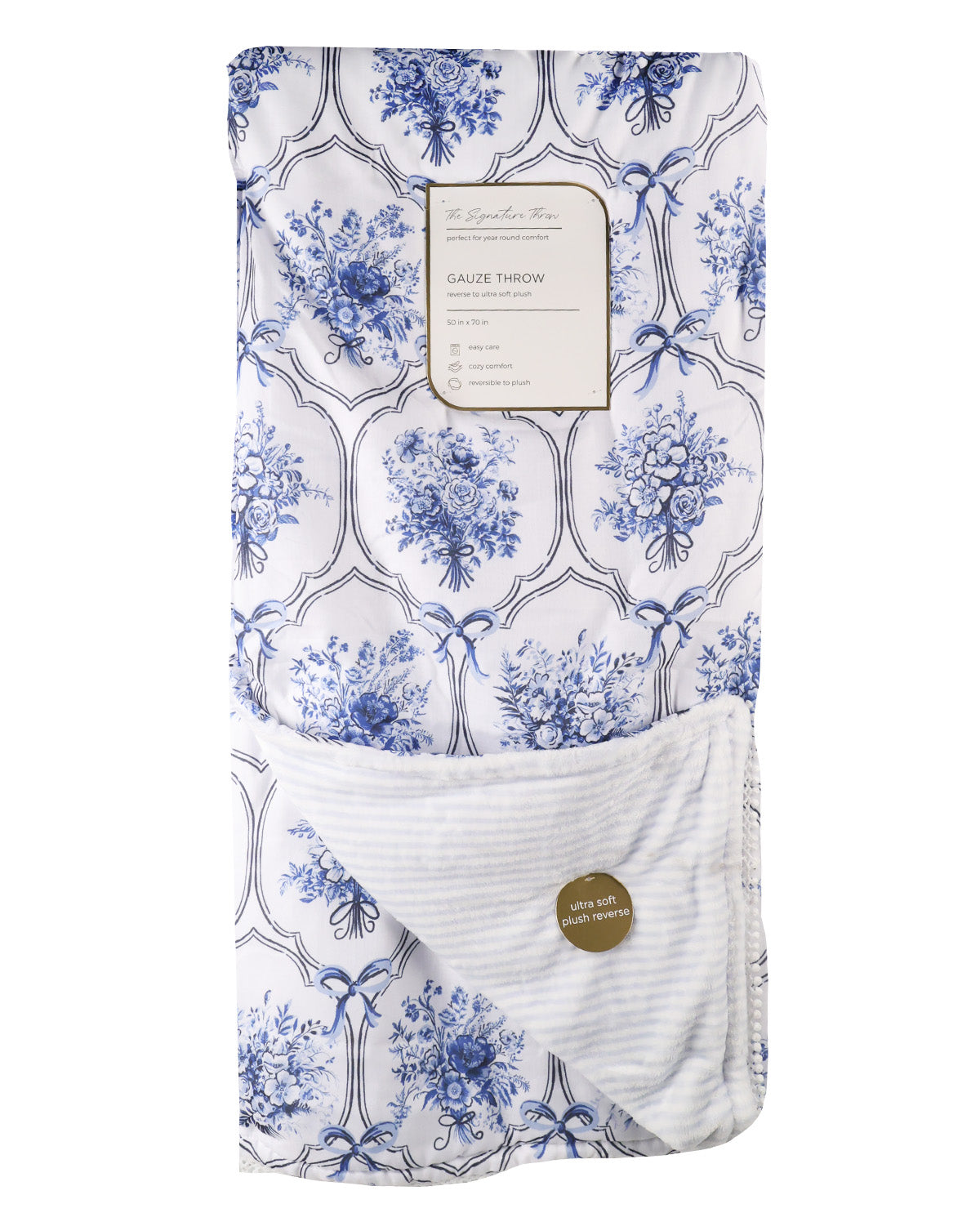 A folded baby blanket featuring a blue and white toile floral pattern on the top half and a white ribbed knit reverse side with a small round gold tag, shown on a plain white background.