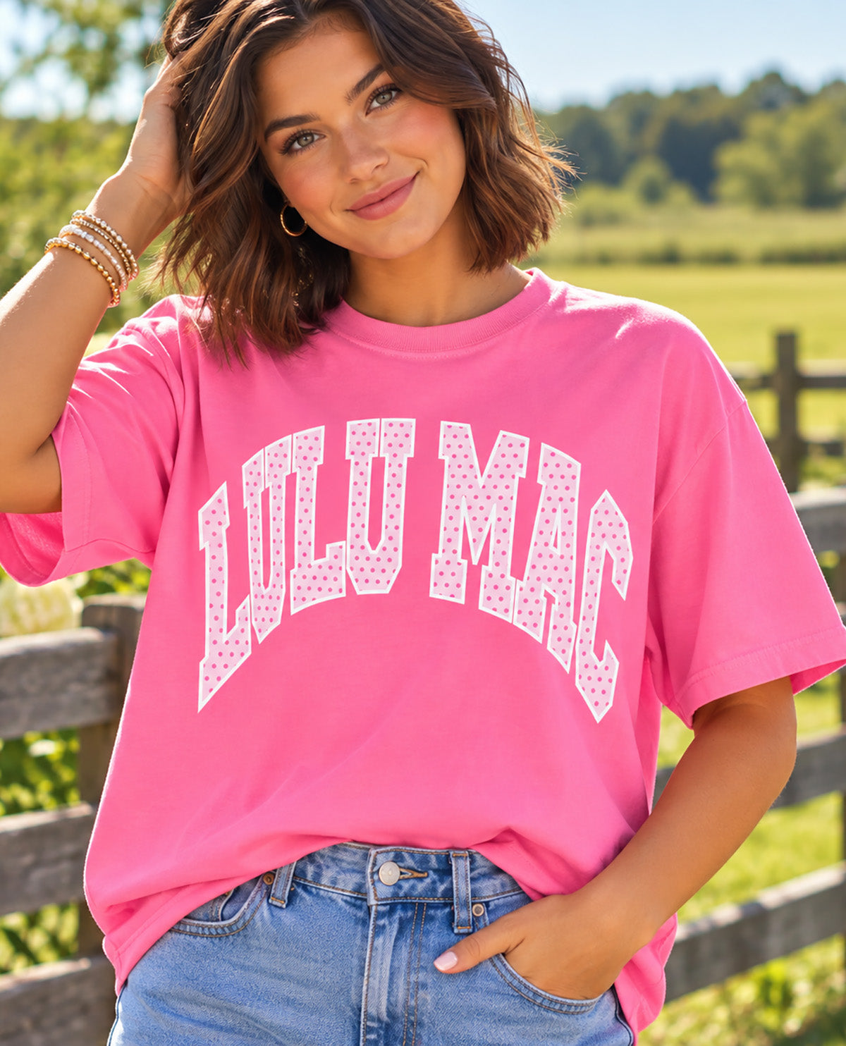 Missy model wearing a pink t-shirt with LULU MAC design with an outdoor background