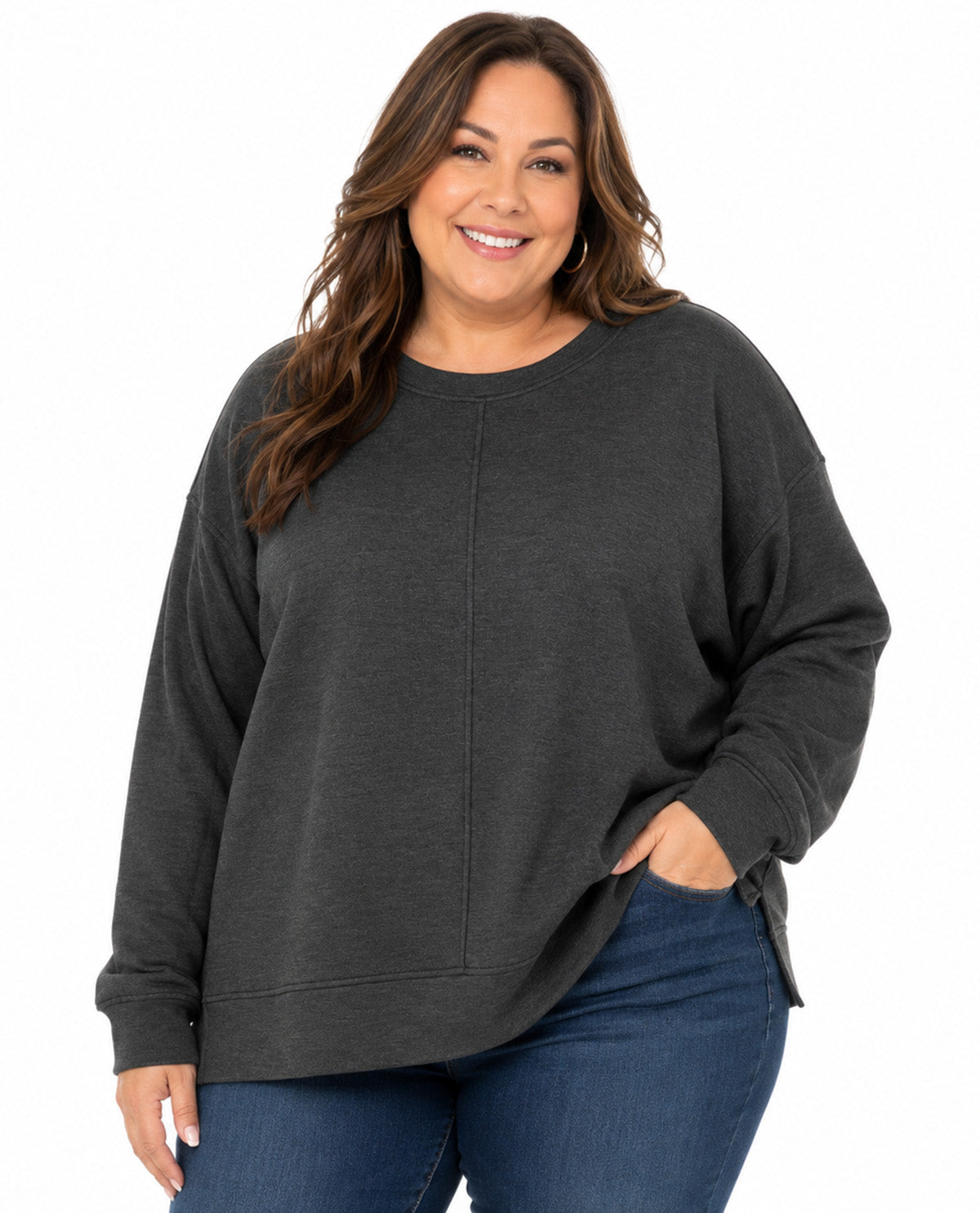 A woman wearing a dark charcoal gray crewneck sweatshirt and blue jeans, standing against a plain white background.