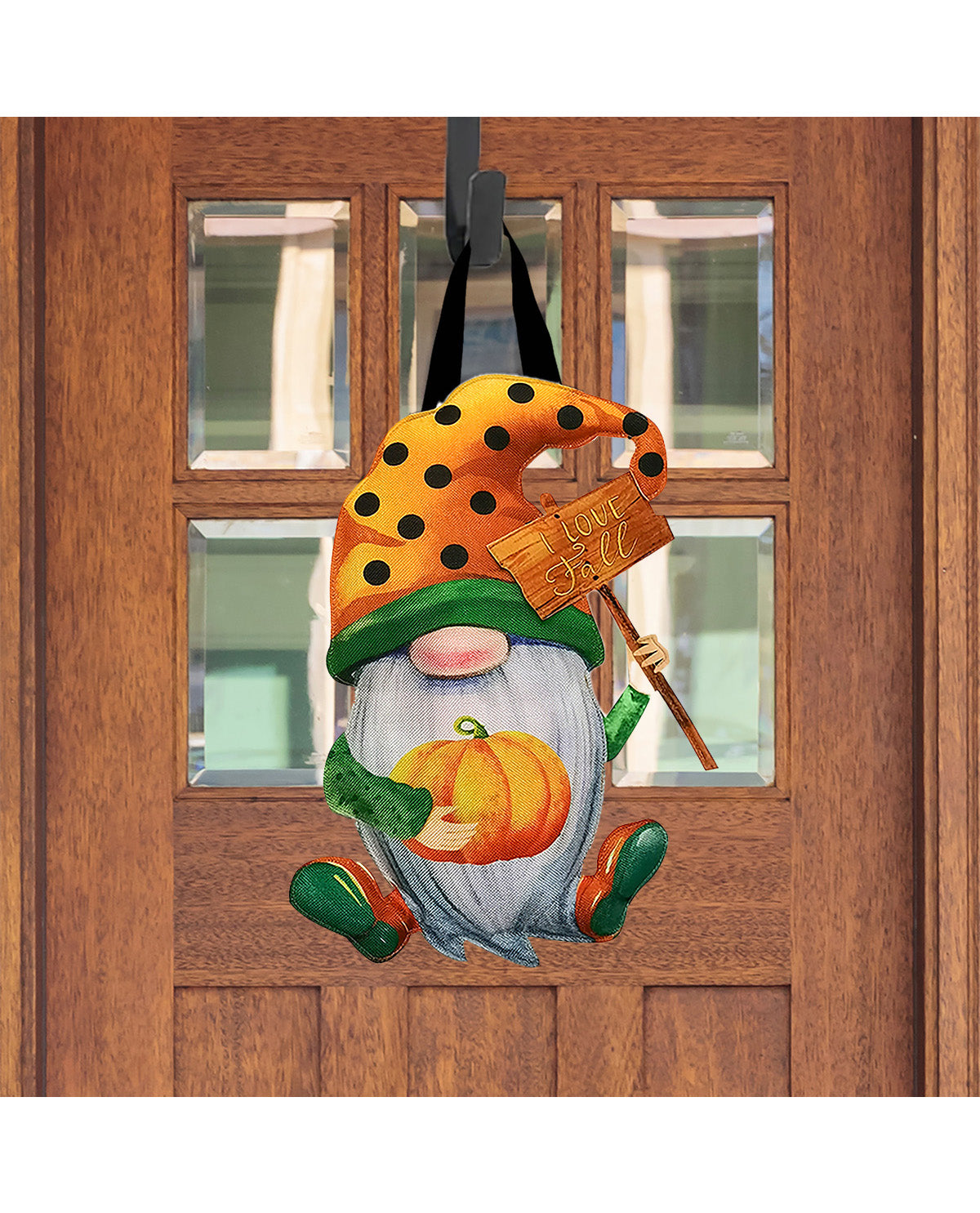 Decorative door hanger of a gnome with a pumpkin and black hat on a wooden door.