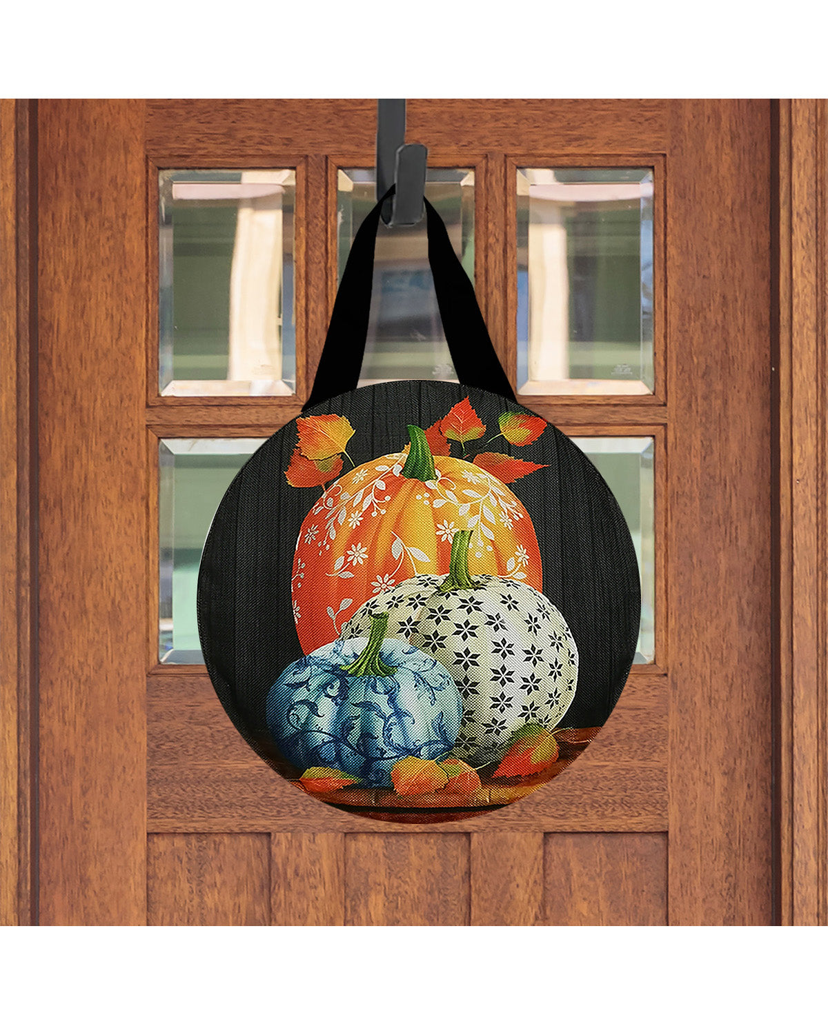 Decorative door hanger with pumpkins on a wooden door