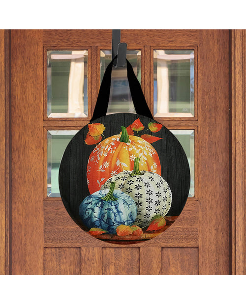 Decorative door hanger with pumpkins on a wooden door