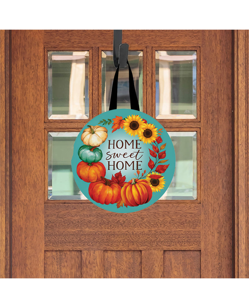 Decorative door hanger with pumpkins and sunflowers on a wooden door.