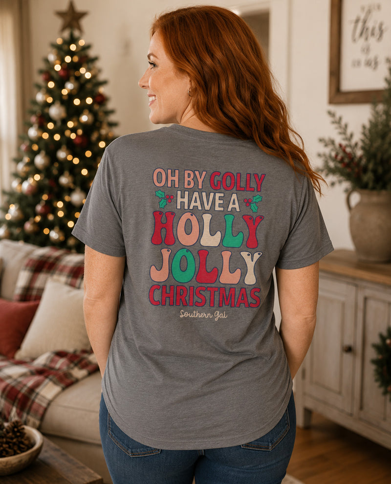 Woman wearing a gray t-shirt with Christmas-themed text in a festive living room.