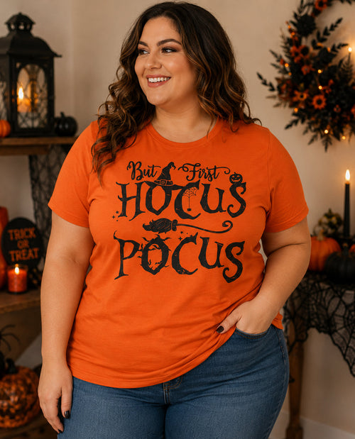 Woman wearing an orange 'Hocus Pocus' t-shirt in a Halloween-themed setting.