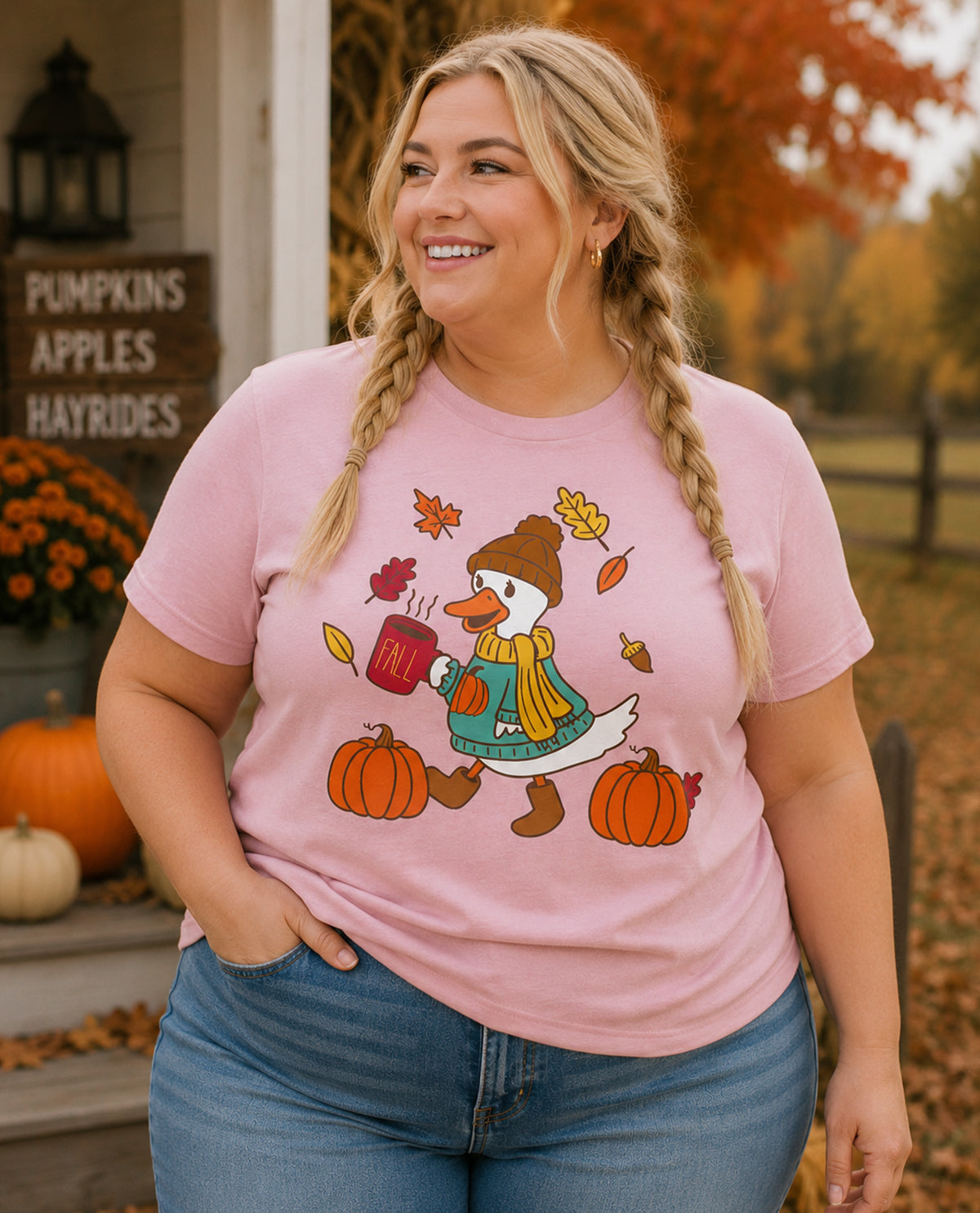 Woman wearing a pink t-shirt with a cartoon duck design in an autumn setting.