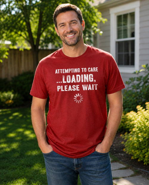 Man wearing a red t-shirt with humorous text in a garden setting