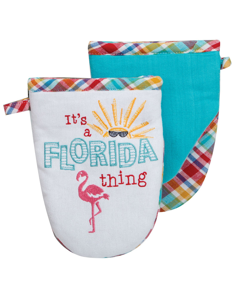 Set of two oven mitts with plaid trim, one white with 'It's a Florida thing' text and flamingo graphic, the other turquoise.