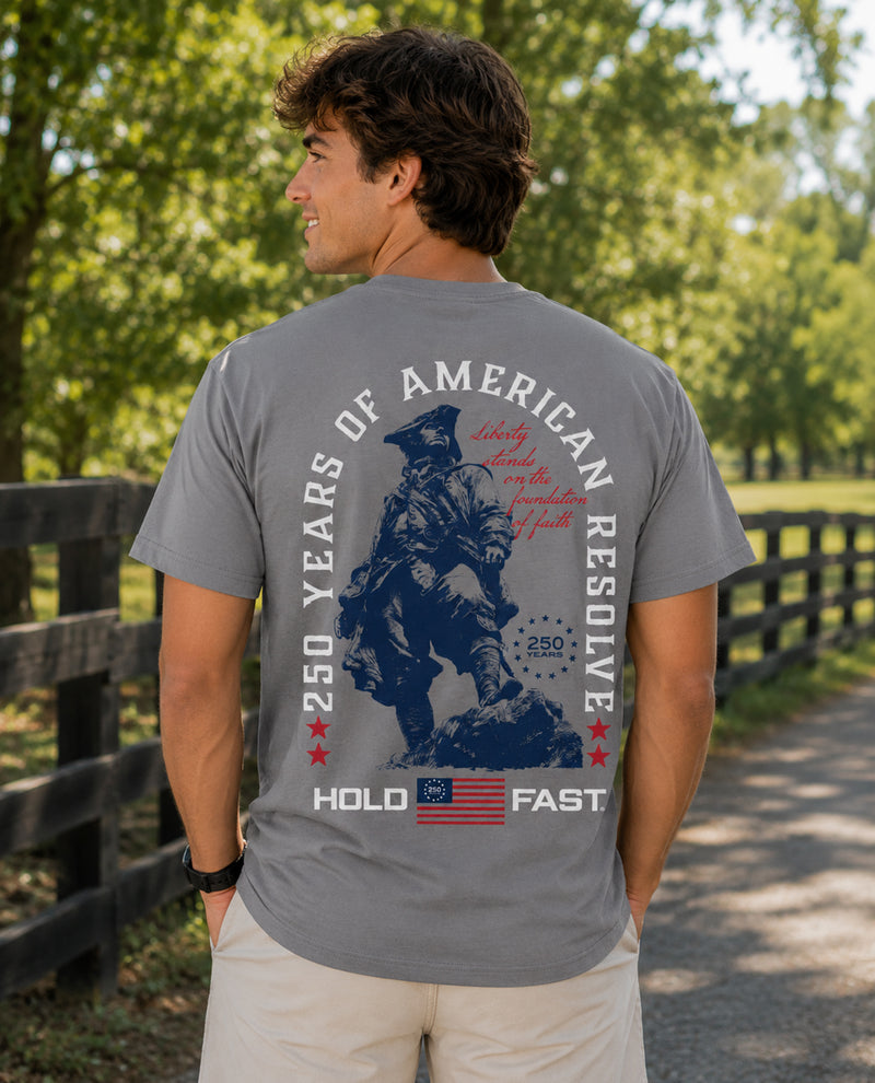 Man wearing a gray t-shirt with a graphic design outdoors