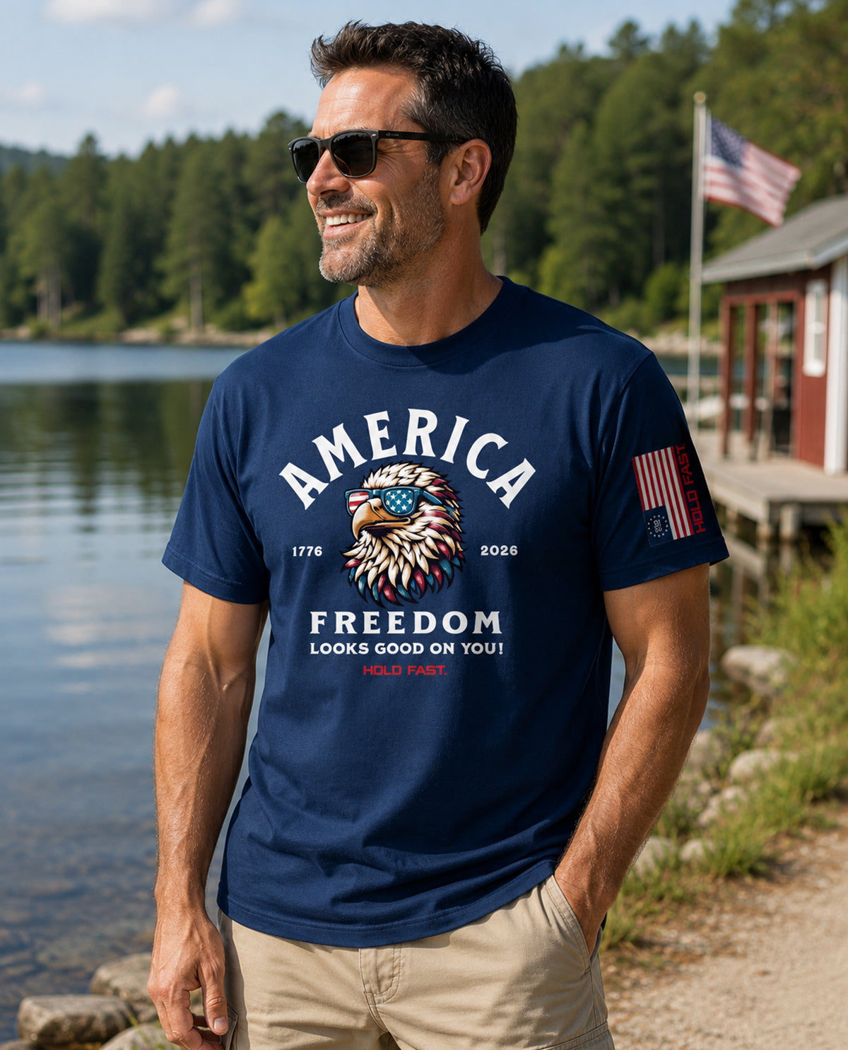 Man wearing a navy blue t-shirt with 'America Freedom' design by a lake.