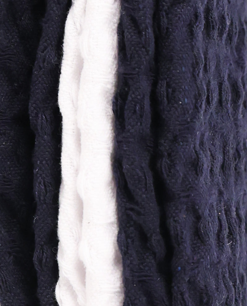 Close-up of a textured knit fabric with vertical stripes in dark navy blue and off-white.