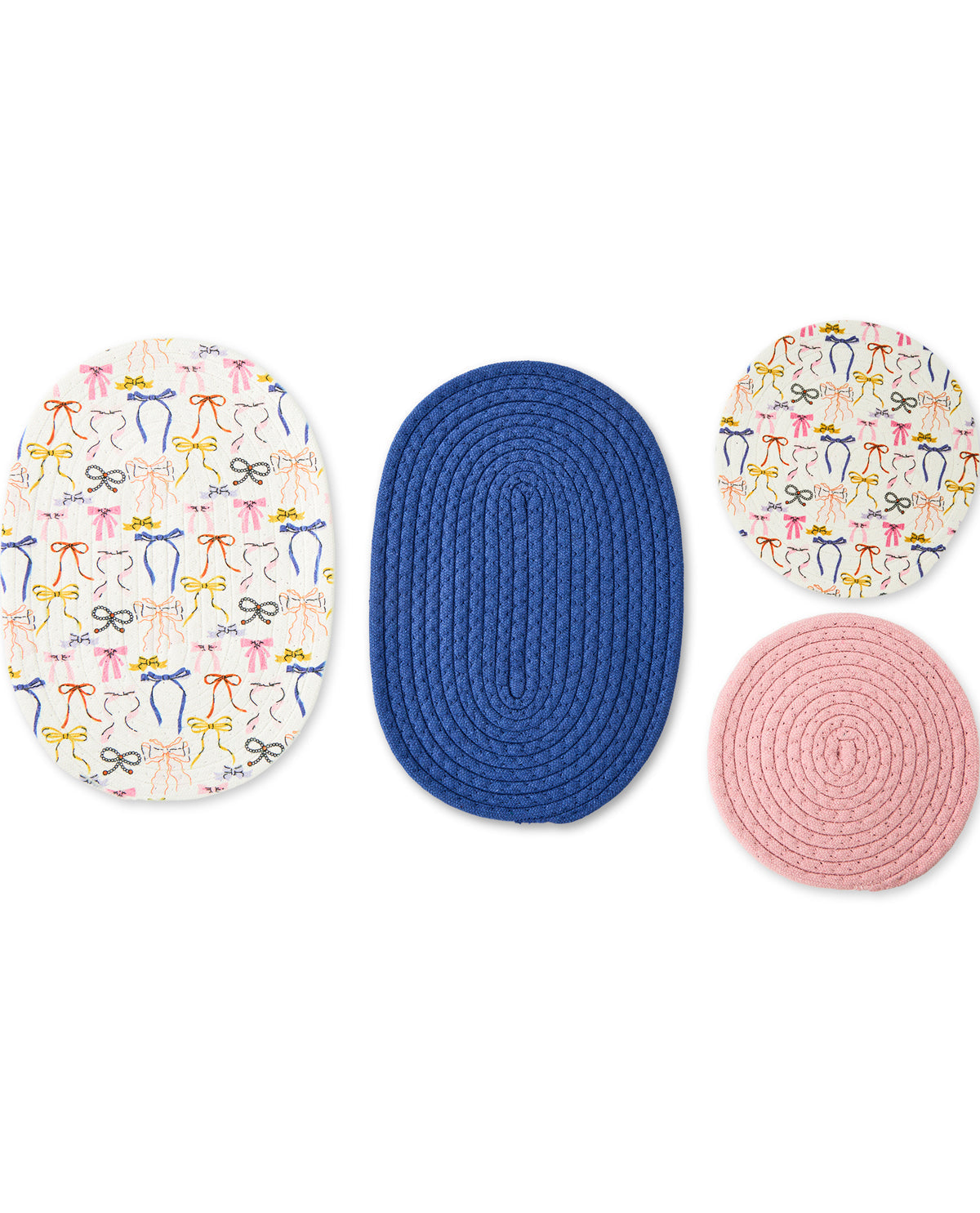 Four braided rope rugs on a white background: two oval rugs with a colorful bow pattern on a white base, one central oval blue rug, and one circular pink rug.