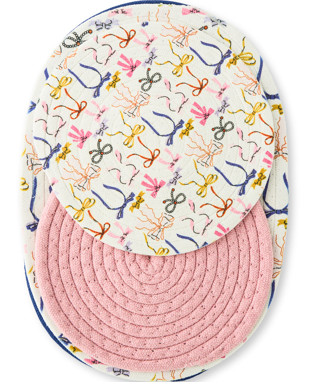 A top-down view of a round patchwork hat featuring a white front panel with a colorful embroidered bow pattern and a pink ribbed fabric crown.