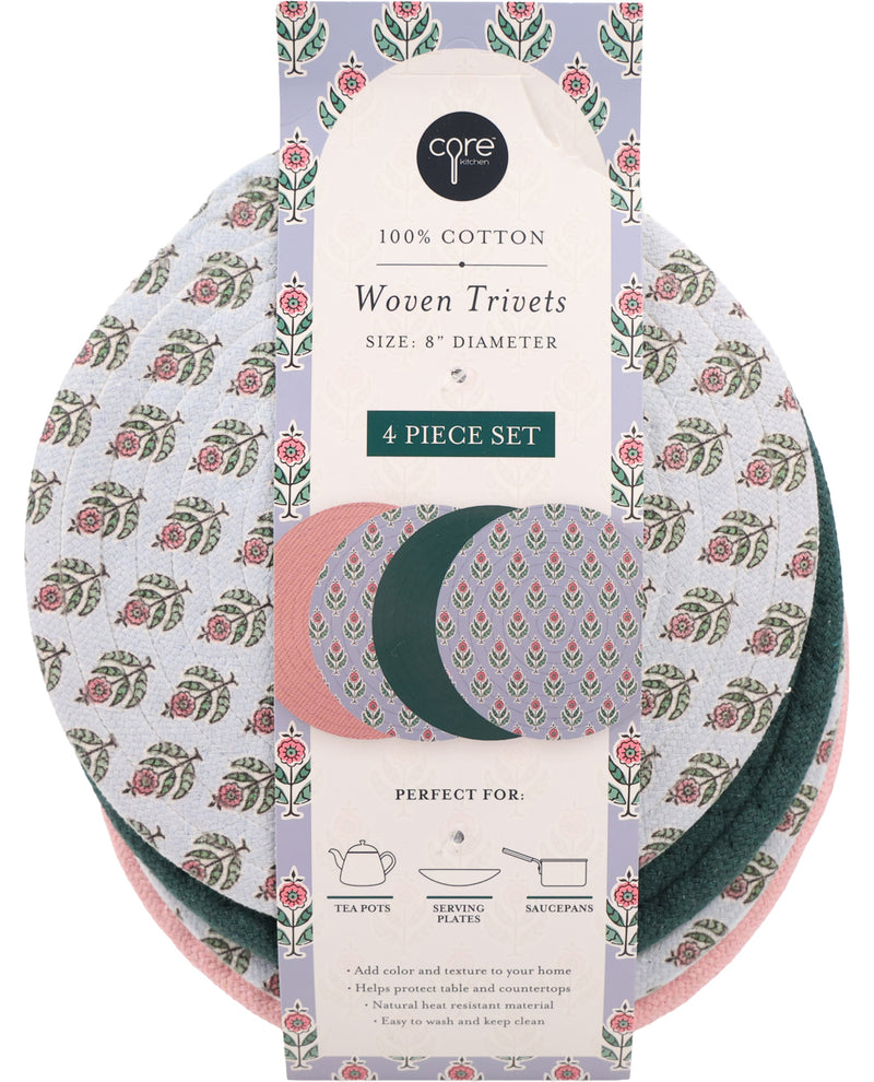 A 4-piece set of Core brand woven cotton trivets in a floral block-print pattern, packaged on a decorative cardboard sleeve. The set includes three trivets: one white with pink and green floral motifs, one dusty pink, and one dark green.