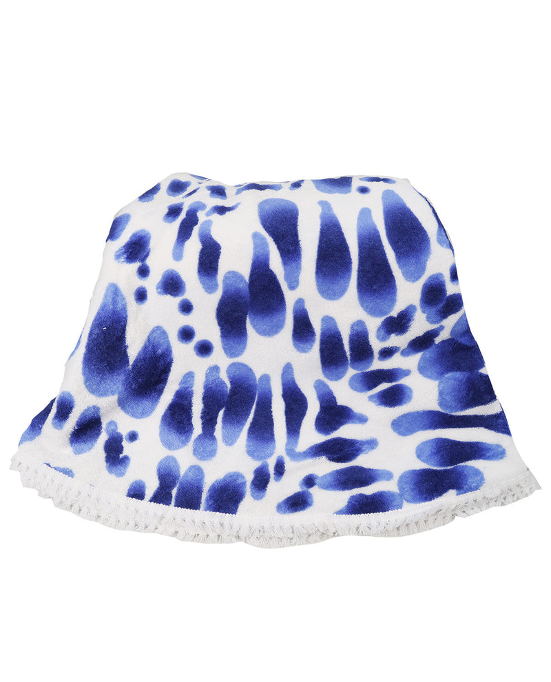 A white knit poncho or cape featuring a blue tie-dye style abstract pattern and a fringed hem, displayed against a solid white background.
