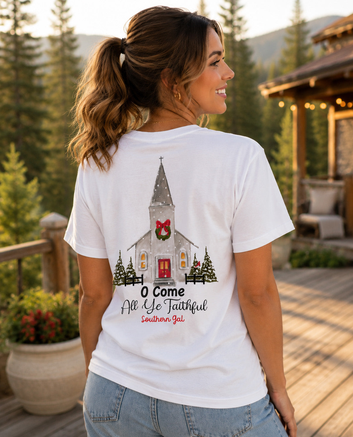 A woman wearing a white graphic t-shirt with a Christmas church design and the text 'O Come All Ye Faithful Southern Gal', photographed from behind in an outdoor setting.