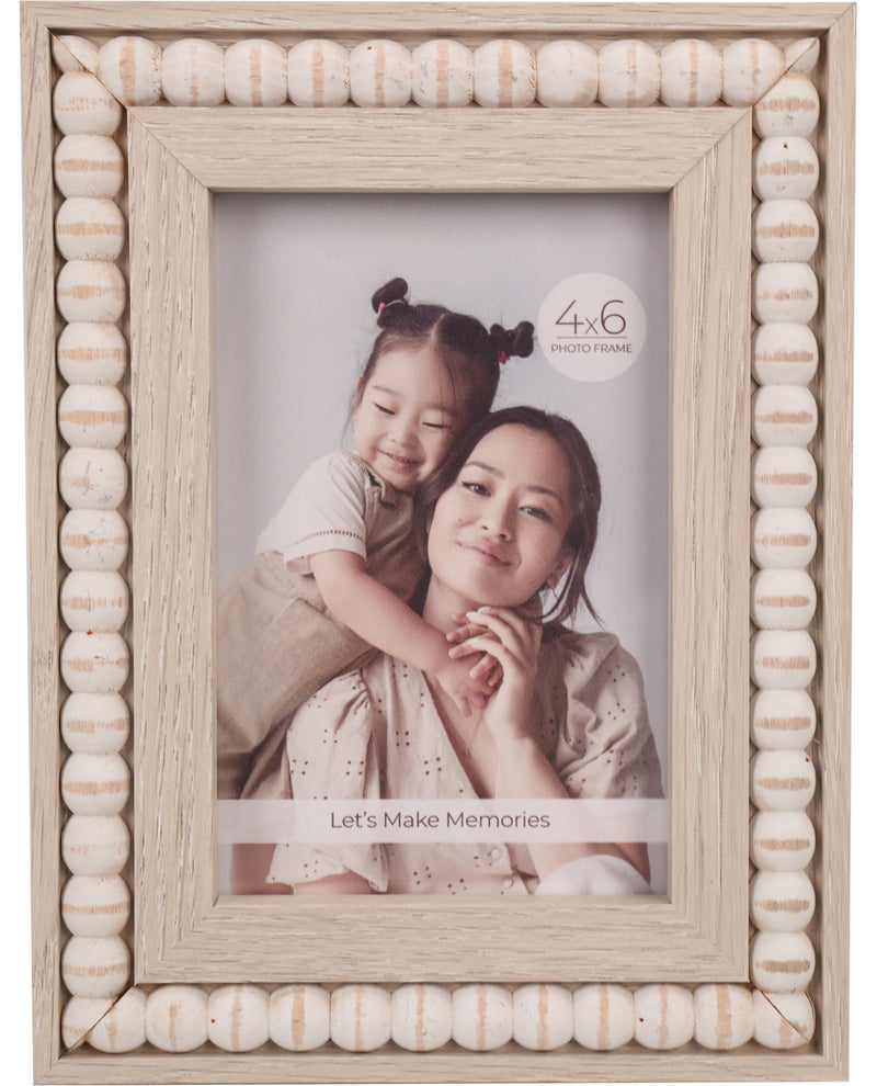 A rectangular wooden photo frame with a decorative border made of stacked round beads in light natural tones. The frame is shown holding a printed photo of a woman and child, with a small '4x6 photo frame' label visible inside the frame.