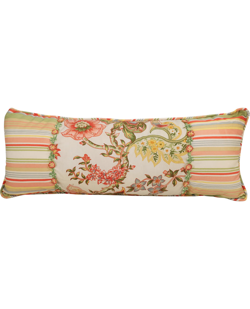 A rectangular lumbar pillow featuring a multi-colored patchwork design with striped borders in green, orange, and beige, and a central panel with a floral and botanical pattern on a cream background.