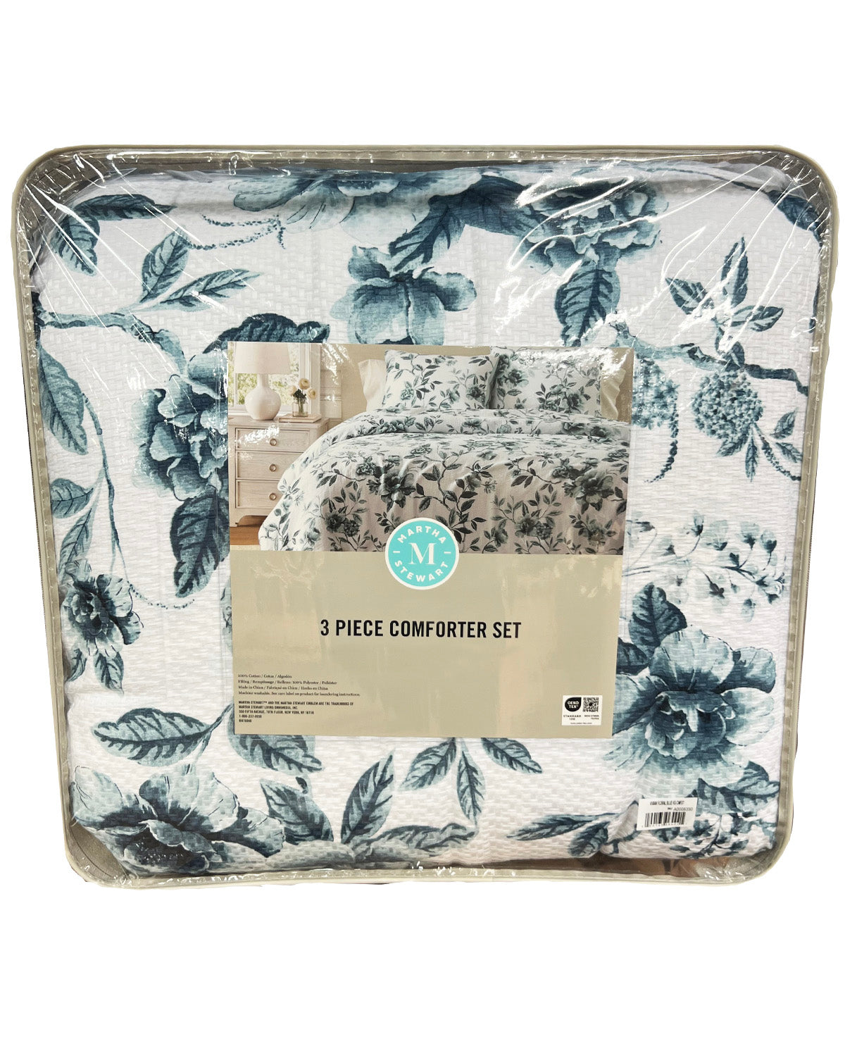 A 3-piece comforter set in a floral toile pattern of navy blue and gray on a white background, packaged in clear plastic with a paper label in the center.