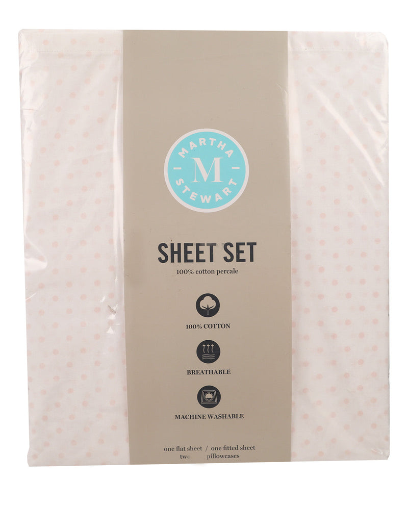 A packaged sheet set by Martha Stewart, featuring a light pink cotton percale sheet with small pink polka dots on either side of a wide taupe center label. The label includes the circular Martha Stewart brand logo and product details.