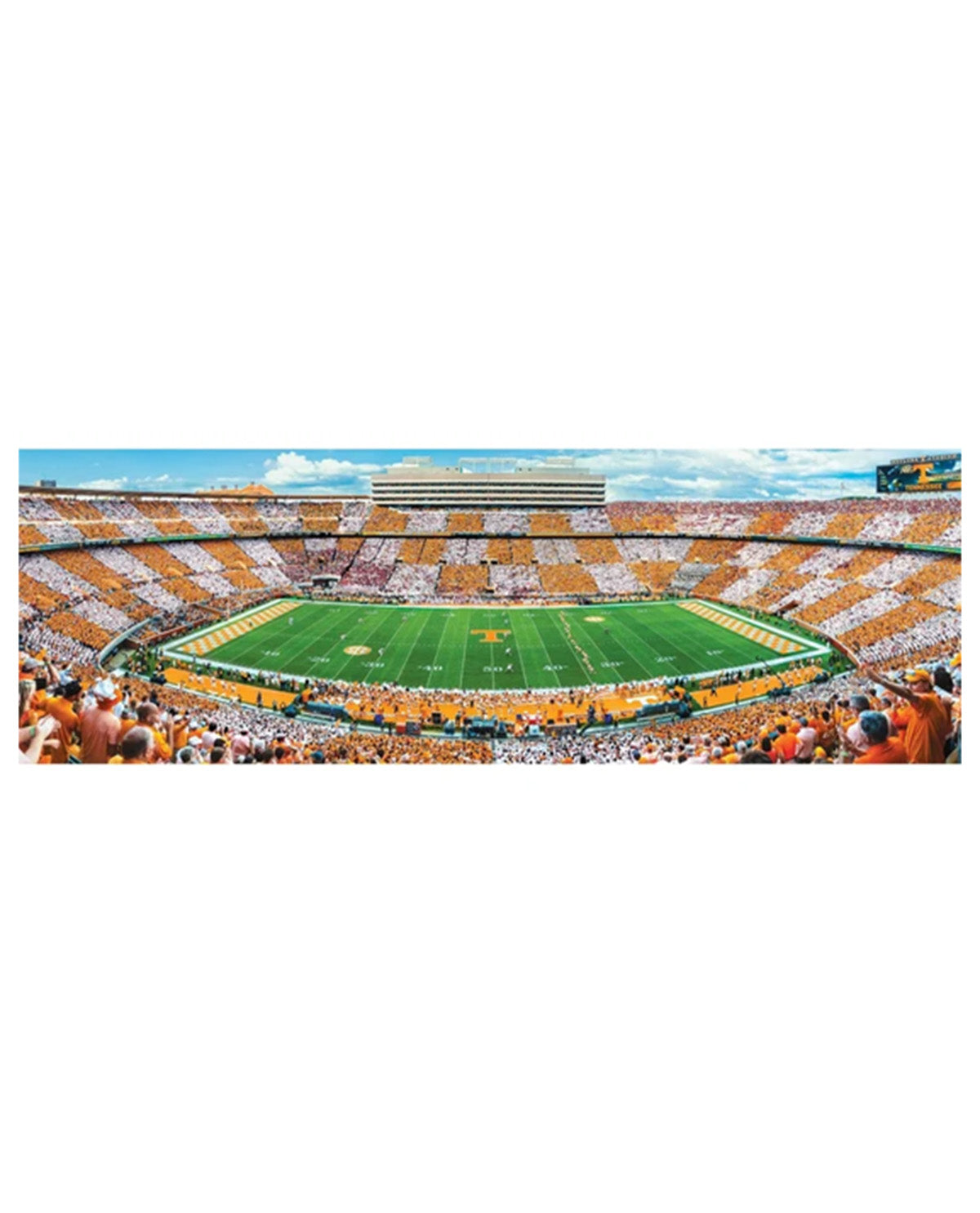 A panoramic stadium scene showing a large football field surrounded by tiered stands filled with spectators in orange, white, and blue, under a blue sky with clouds.
