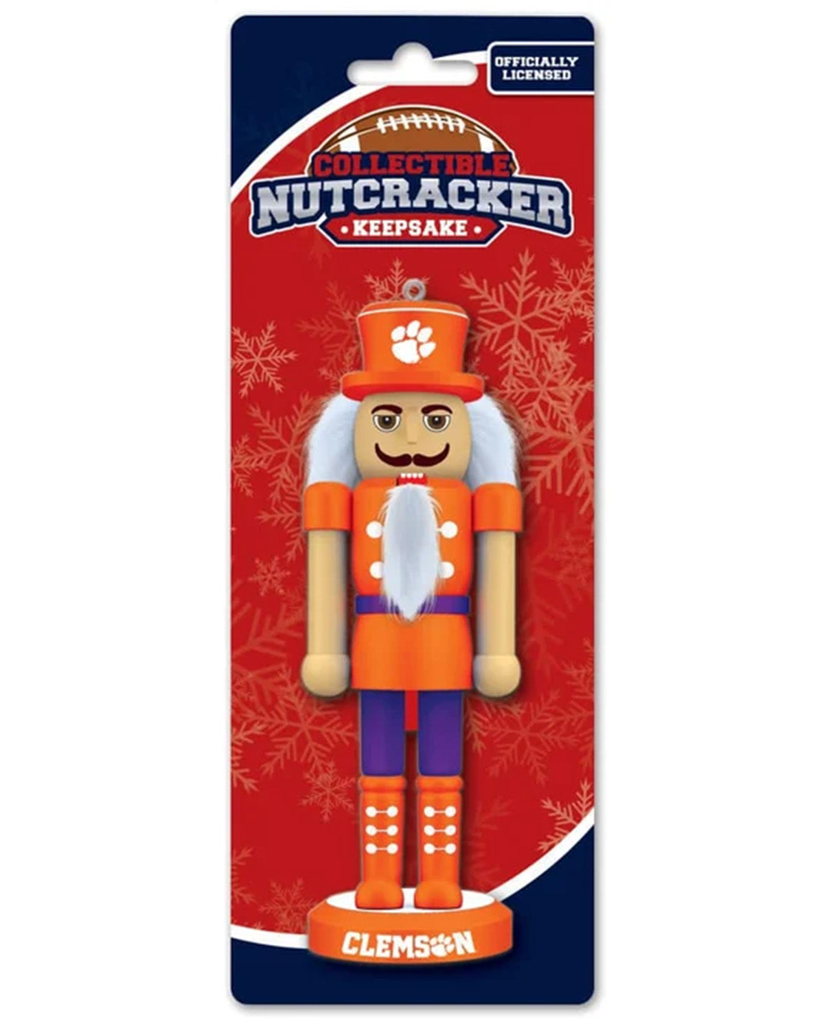 Clemson Tigers collectible nutcracker keepsake in its original retail blister packaging. The nutcracker is dressed in an orange and purple uniform with a white beard and a Clemson paw print hat, mounted on a red and navy blue card with snowflake designs.