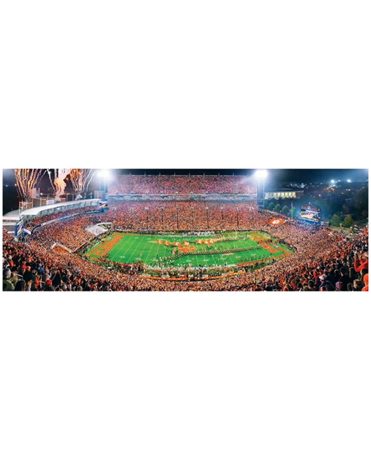 A panoramic night photograph of a packed football stadium with fireworks bursting in the sky above the field, shown as a wide rectangular print with a white border.