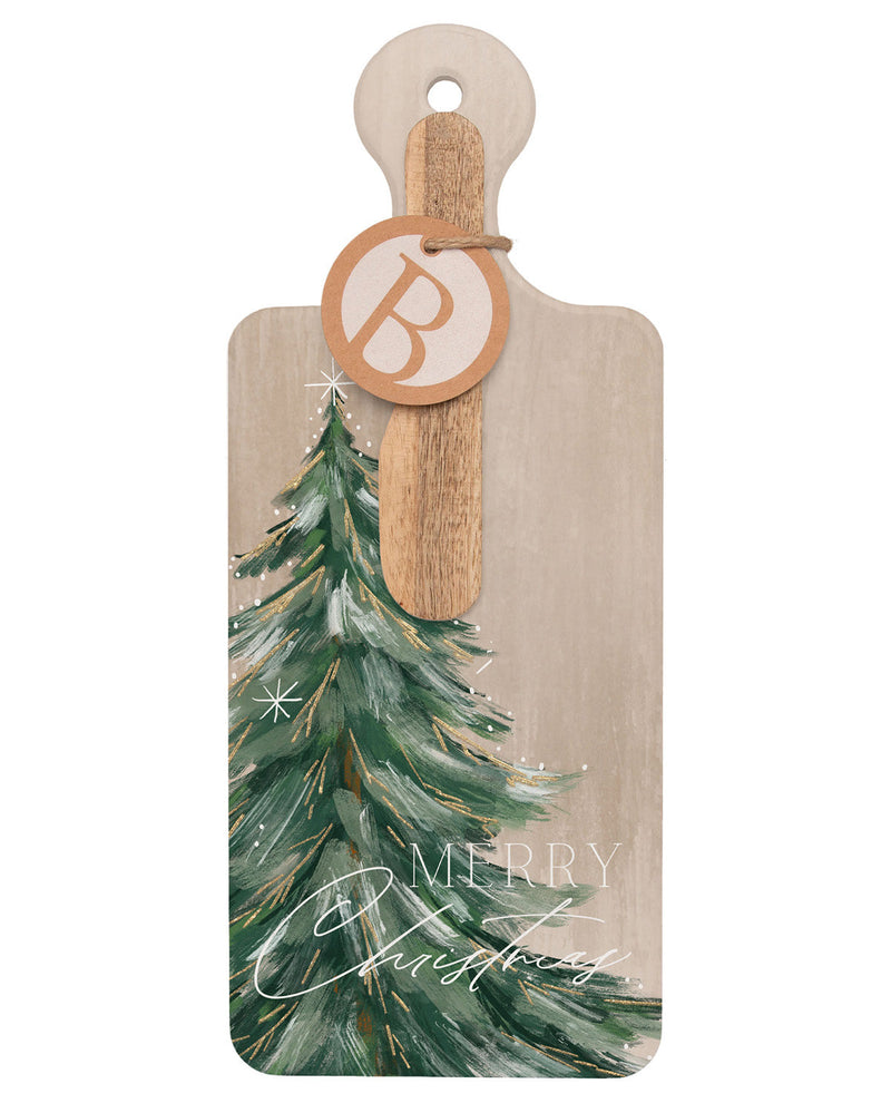 A rectangular wooden serving board with rounded corners and a hanging loop, featuring a painted green Christmas tree and the words “Merry Christmas” on a light beige background. A round wooden tag with a monogram letter B is attached with string.