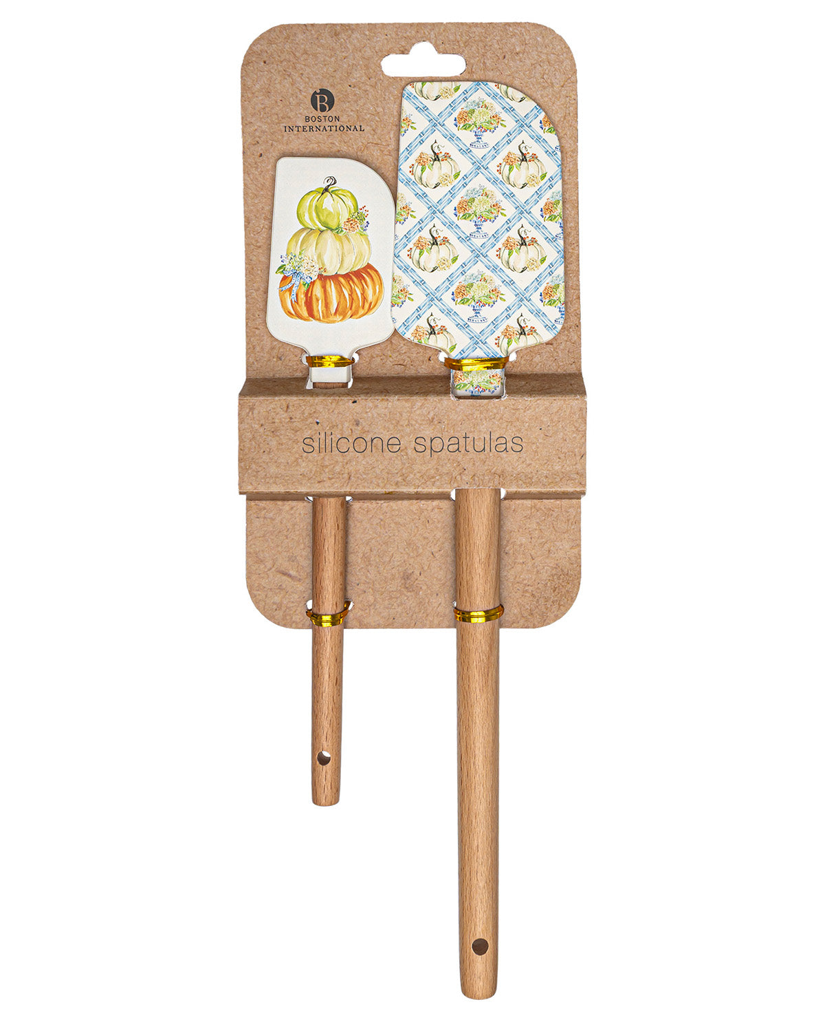 A set of two silicone kitchen spatulas with light wood handles, presented in their original brown kraft paper packaging. The spatula heads feature a blue and white diamond pattern with small yellow birds, and the other has a white background with stacked orange and yellow pumpkins.