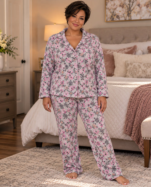 Missy model wearing a two piece long sleeve pj set with a pink and gray floral design with a bedroom background