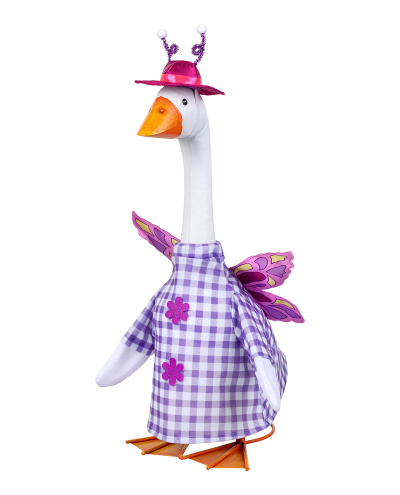 A plush goose decoration or doll with a long white neck, orange beak and feet, wearing a purple-and-white gingham dress with flower appliqués, a pink hat, and butterfly wings, isolated on a white background.