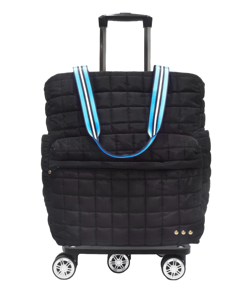 A black quilted rolling suitcase with an integrated tote bag, featuring light blue, white, and black striped handles, a telescoping handle, and four spinner wheels.