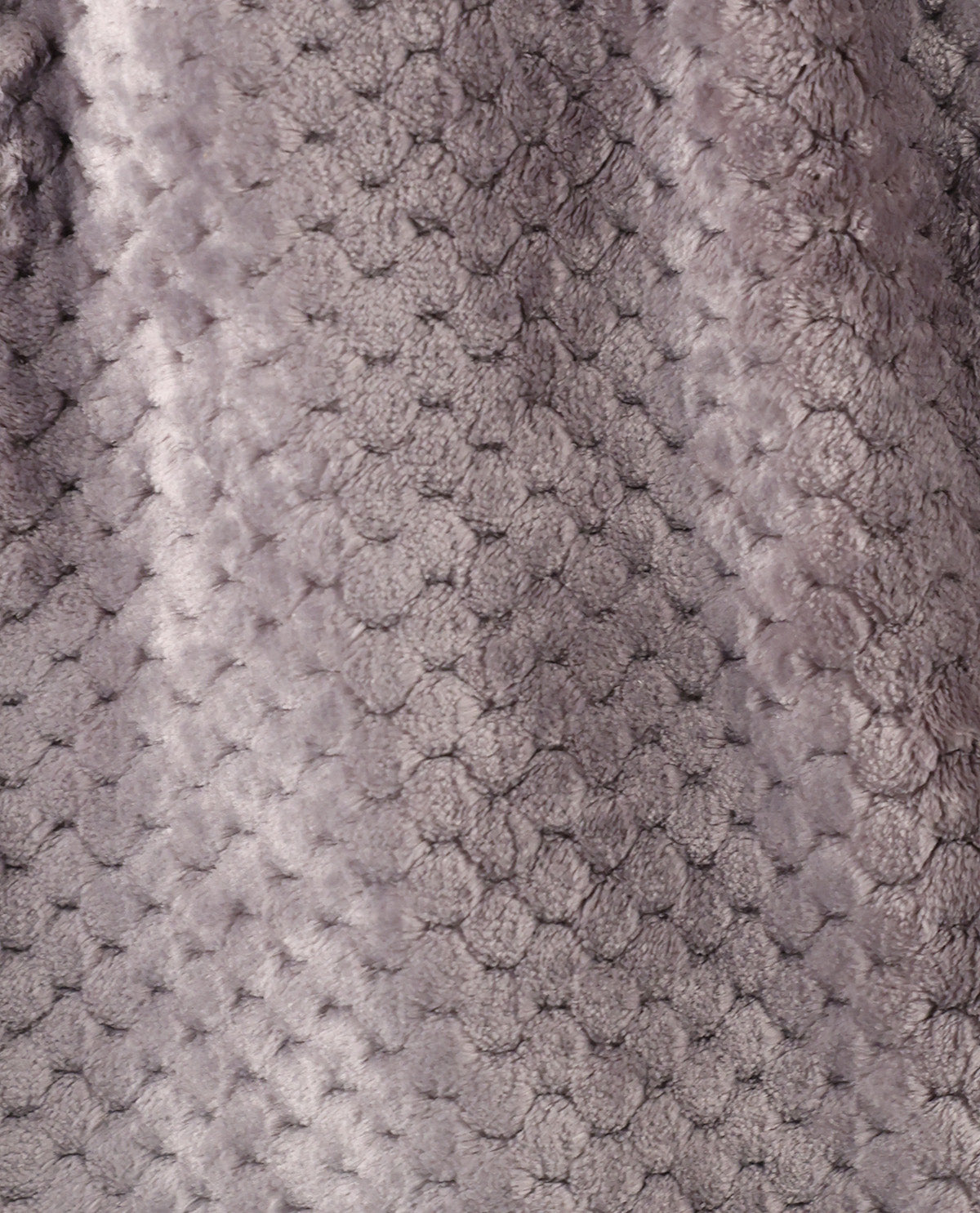 Close-up of a textured plush fabric with a raised honeycomb or bubble pattern in a soft taupe-gray color.