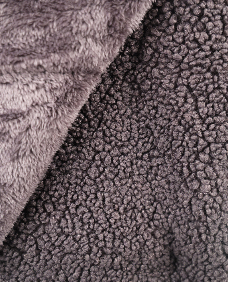 Close-up of a plush sherpa fabric in a dark charcoal gray color, showing the textured loop pile and a folded lighter gray section.