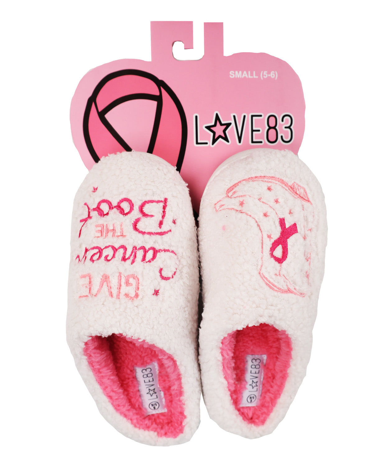 A pair of white sherpa slippers with pink lining and pink printed designs, attached to a pink retail hanger card. The left slipper reads 'The Book Cancer Give' and has a pink shoe print, while the right slipper has a pink ribbon and star print.
